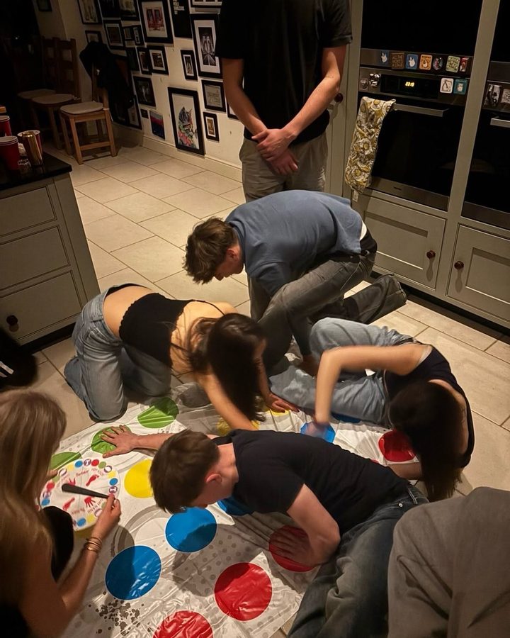 Friends playing twister in a kitchen, before